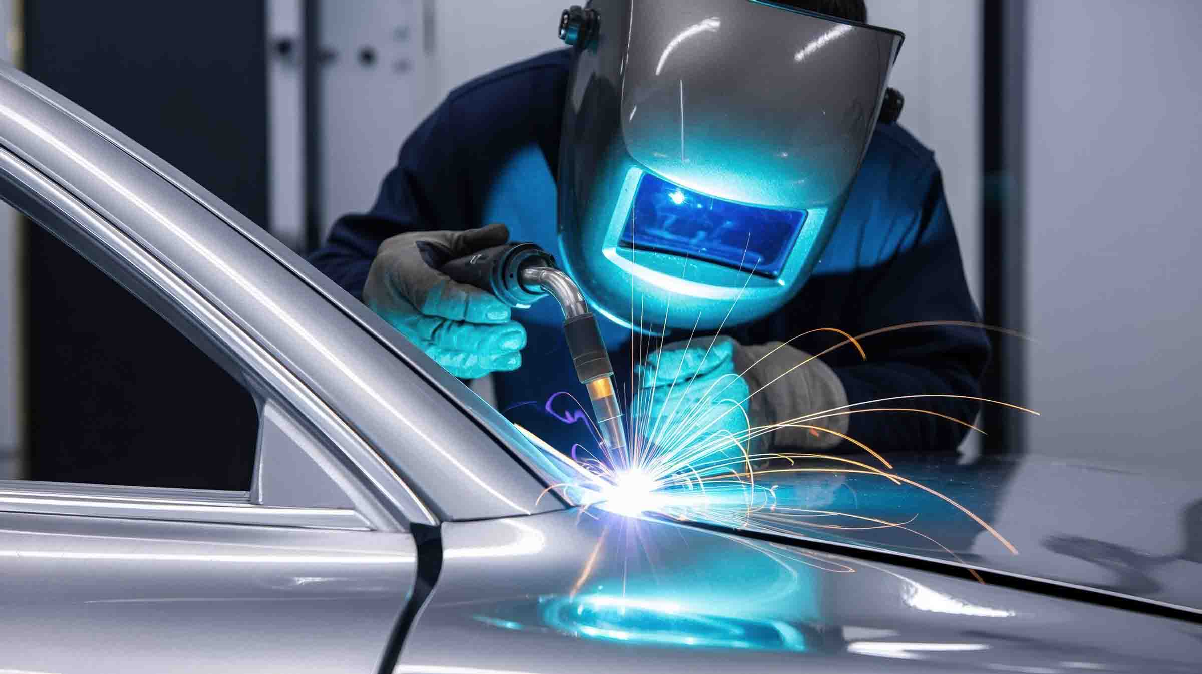 i-car certified technician welding hood of silver vehicle - hi tech auto collision & repair